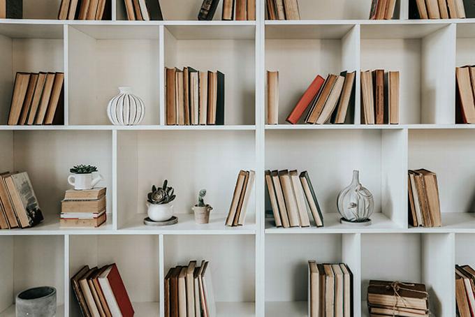 simple white bookcase filled with books and ordiments